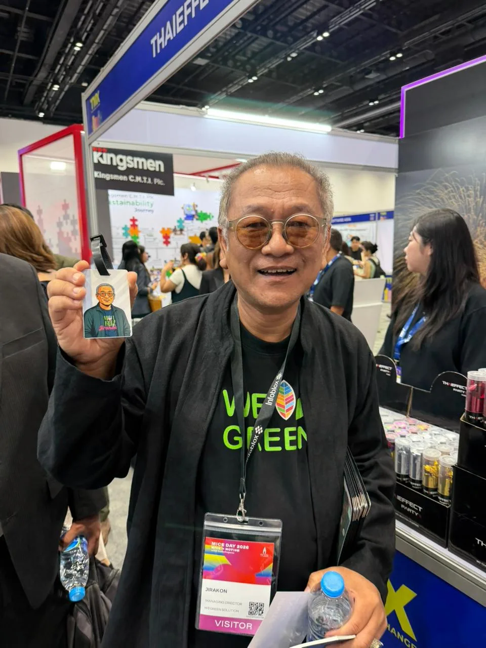TMX visitor holding up his finished caricature bag tag at the Blue Apple International stand